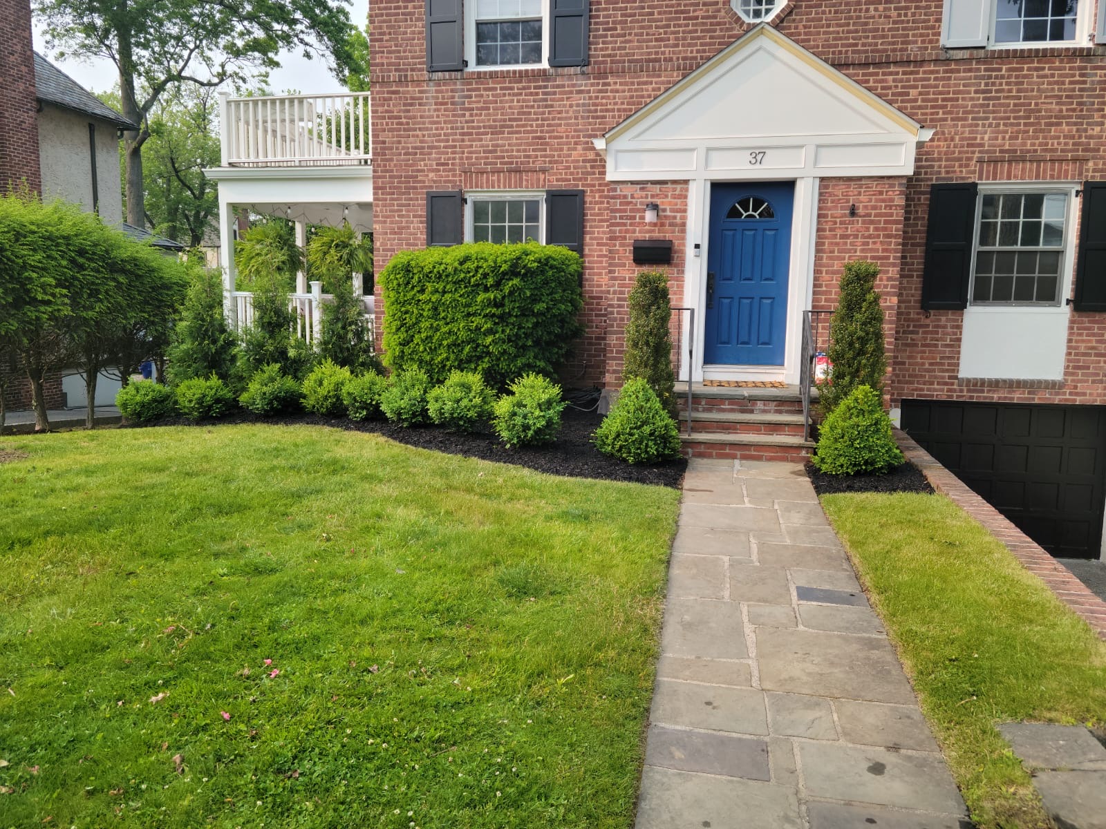 Brick colonial with boxwood and bluestone walk